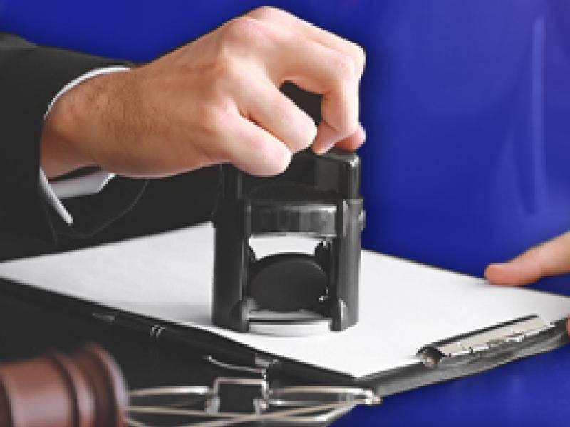 photo of a hand stamping a document